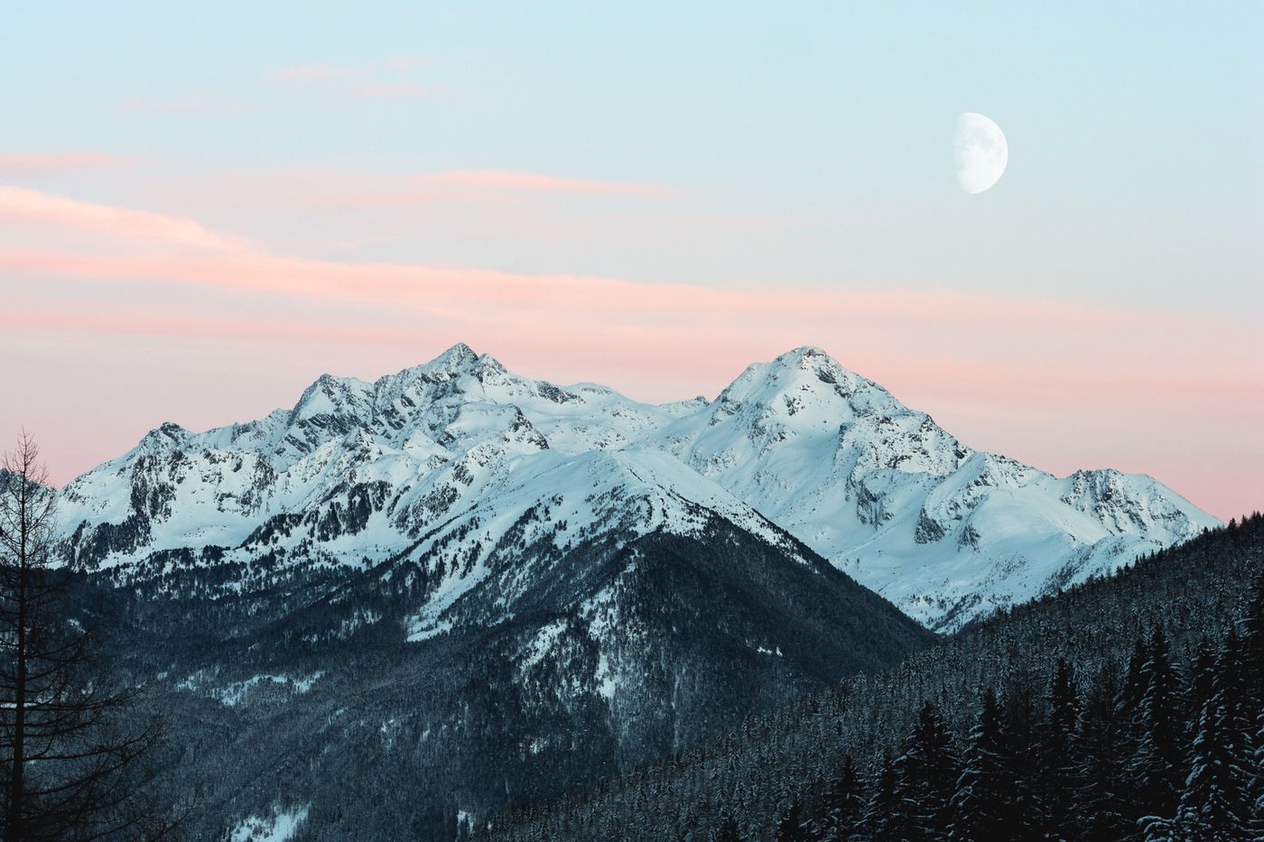 Snow-covered mountain range beneath a soft evening sky