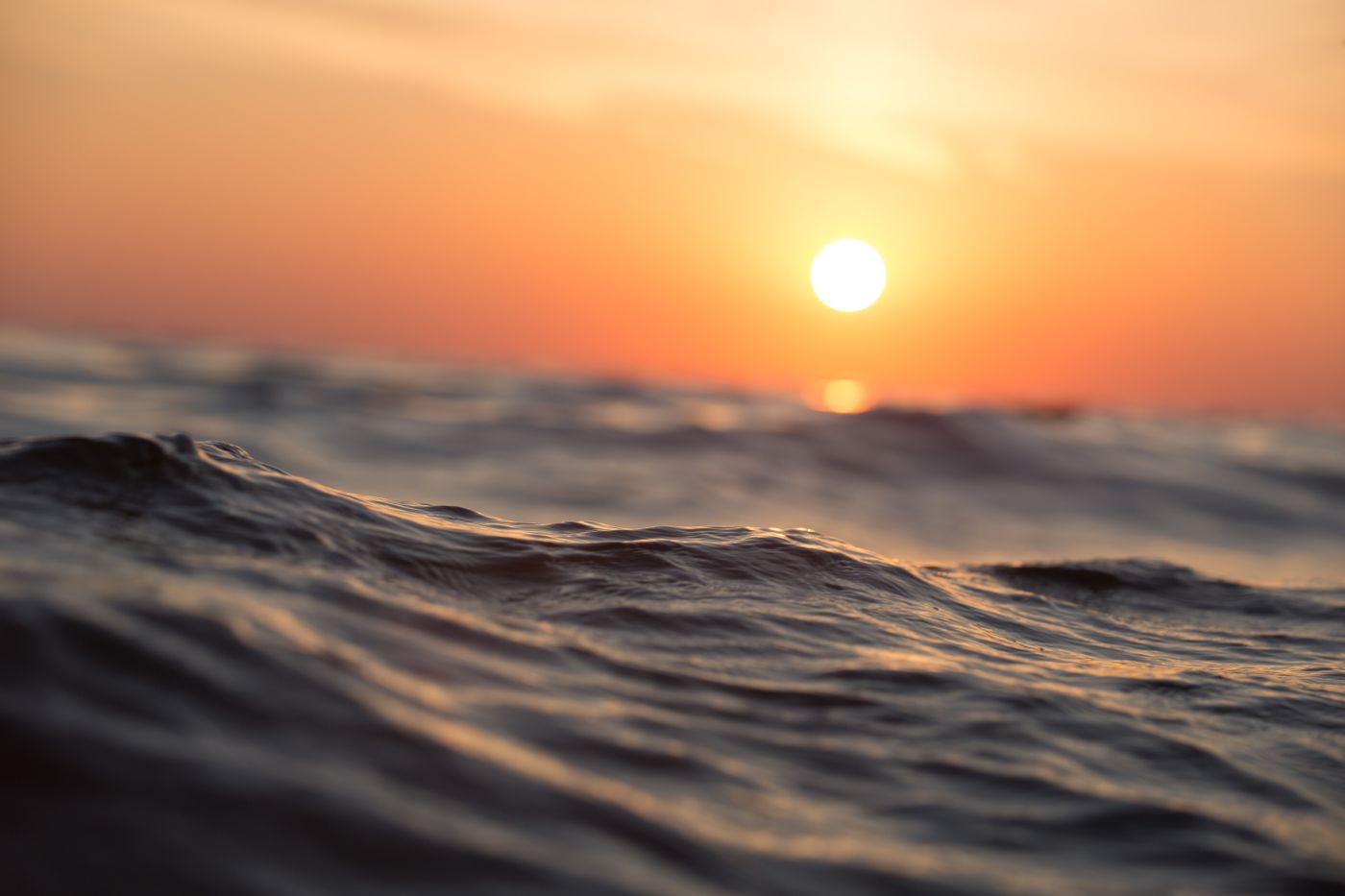 Sunset over gently rolling ocean waves