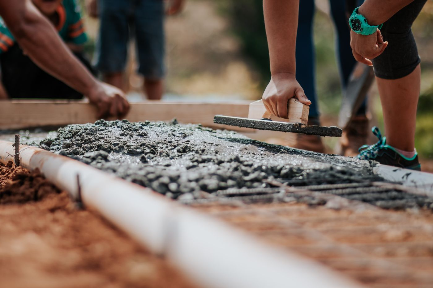 Construction workers levelling a concrete surface