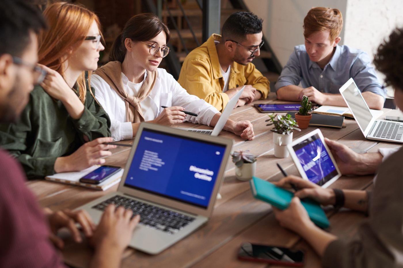 A group reviewing documents and laptops