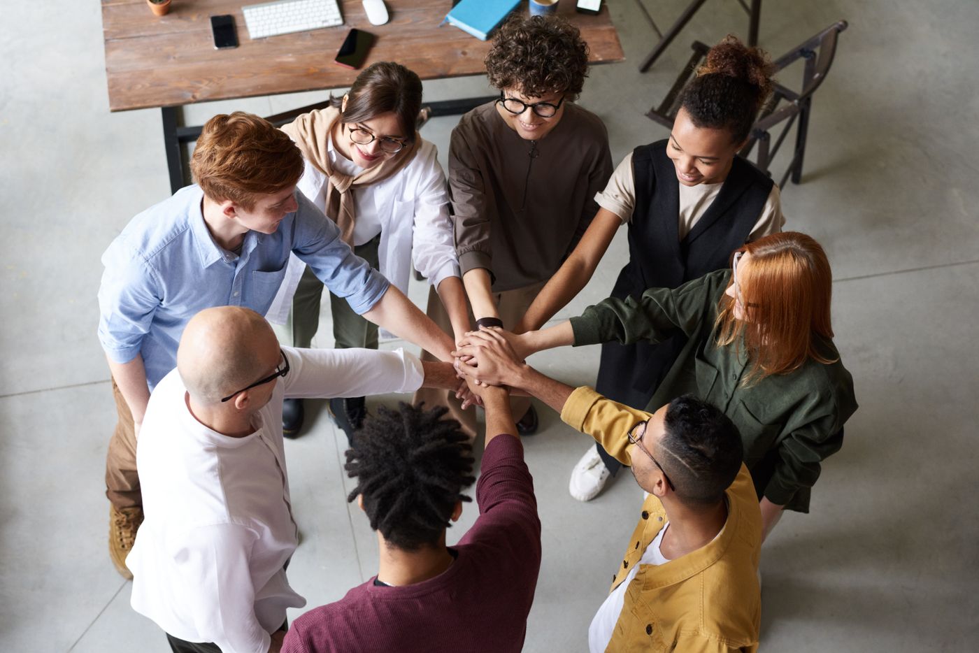 Colleagues joining hands above a meeting table